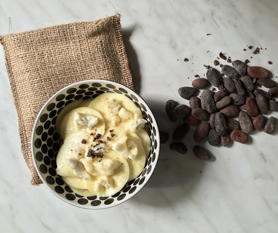 Bowl of corzetti pasta dressed with gorgonzola cheese and topped with cocoa beans