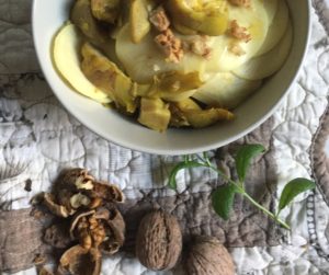 Bowl filled with corzetti pasta dressed with a sauce of artichocke, turmeric and walnuts
